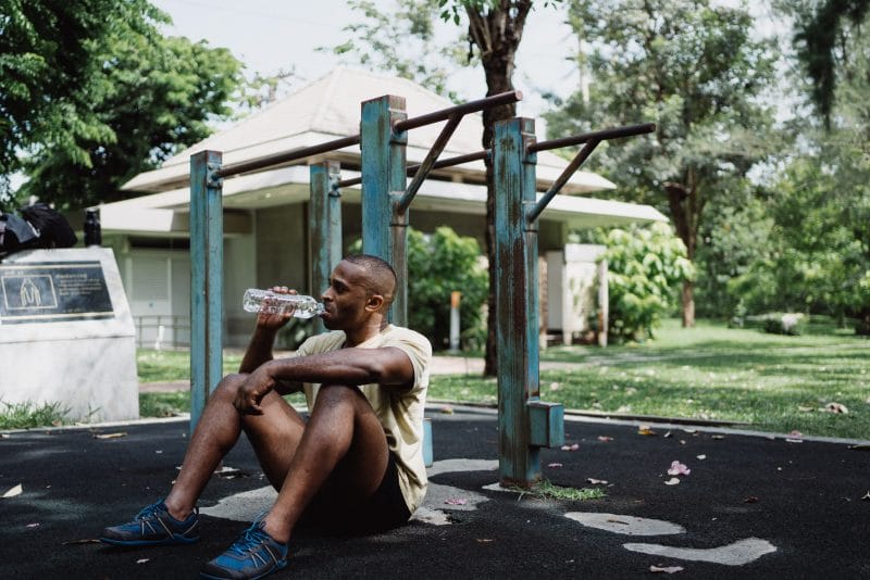 man sitting while drinking water